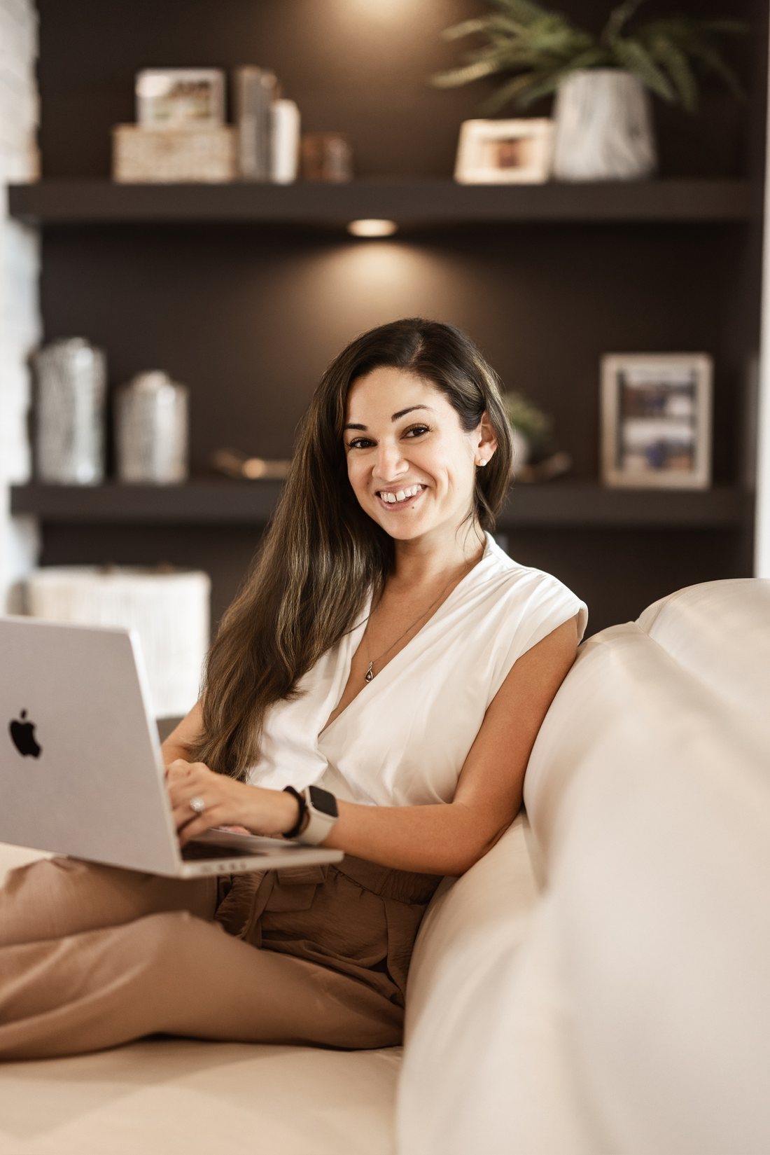 Business owner working on a laptop on a soft cream sofa